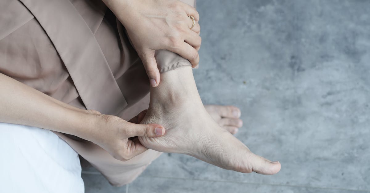 A person gently holding their ankle and foot, showcasing relaxation or foot care.