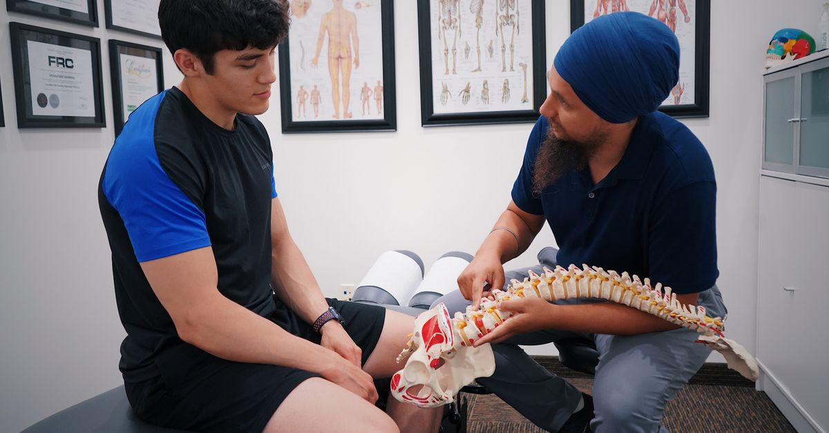 Clinician showing a patient a model of the spine.