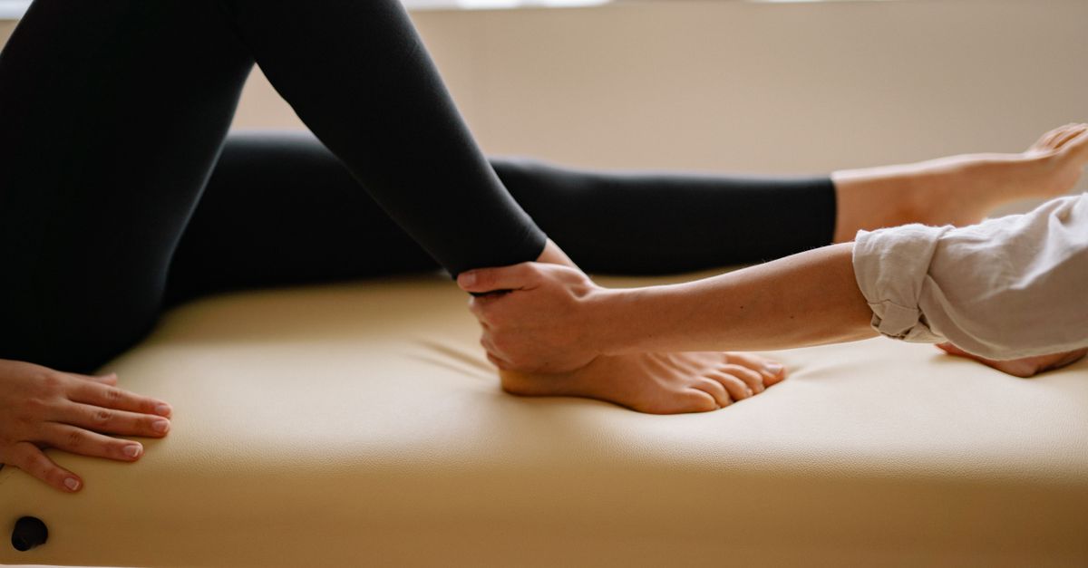 Close-up of a therapist performing a foot massage during a therapy session indoors.
