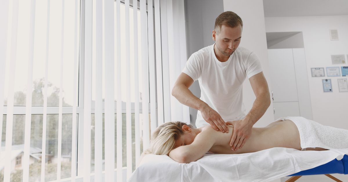 A massage therapist provides a relaxing back massage in a modern clinic setting.