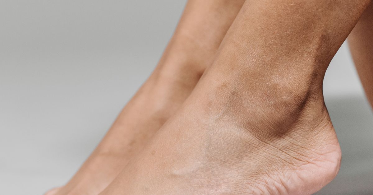 Close-up of bare heels with feet raised on tiptoe.