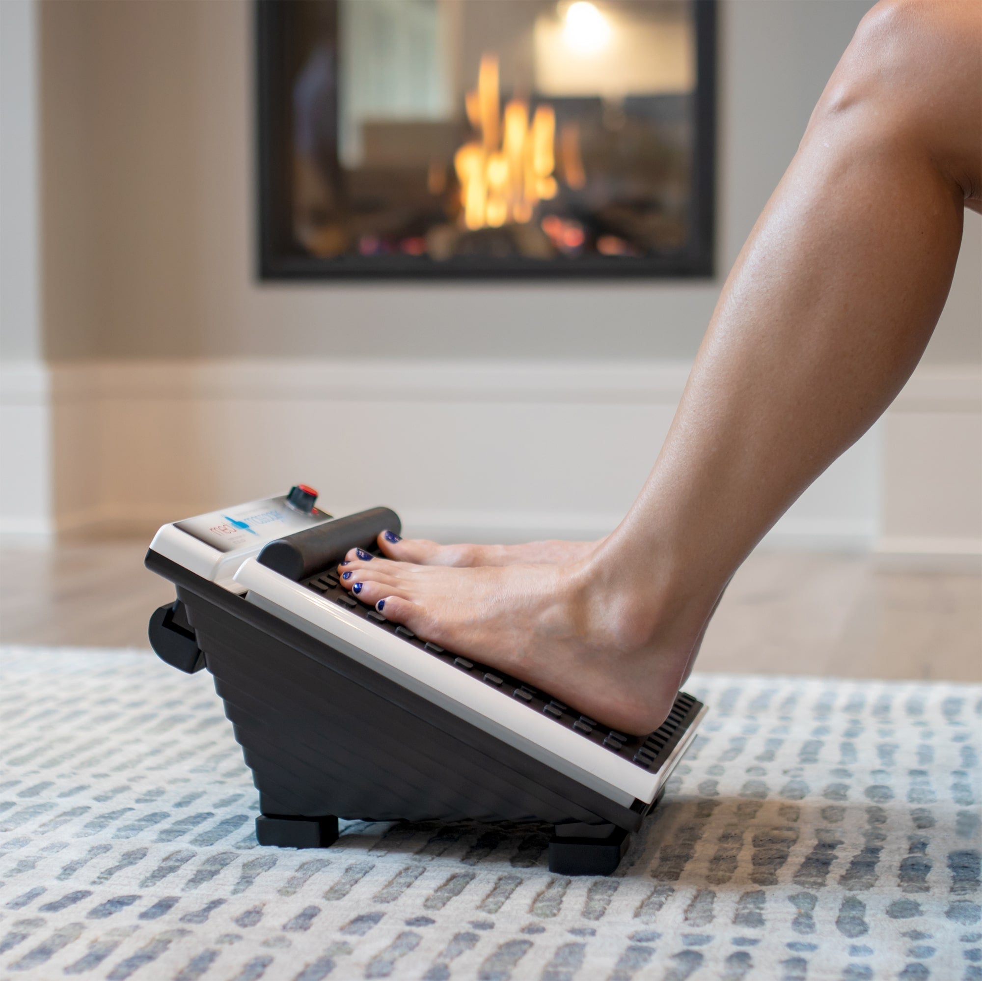 Person relaxing at home using MedMassager Foot & Body Plus Combo (Reconditioned) foot massager on a patterned rug.