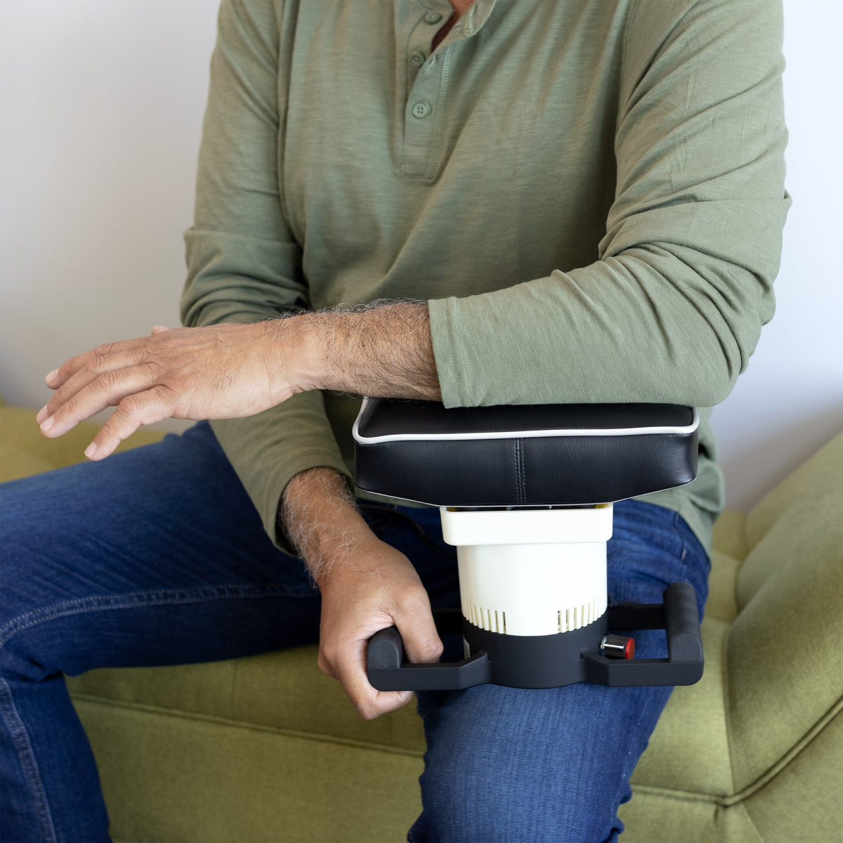 Person relaxing on a couch while using a MedMassager Body Massager.