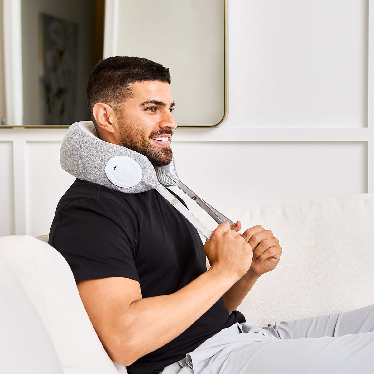 Man relaxing on a couch using a MedMassager Neck Massager.