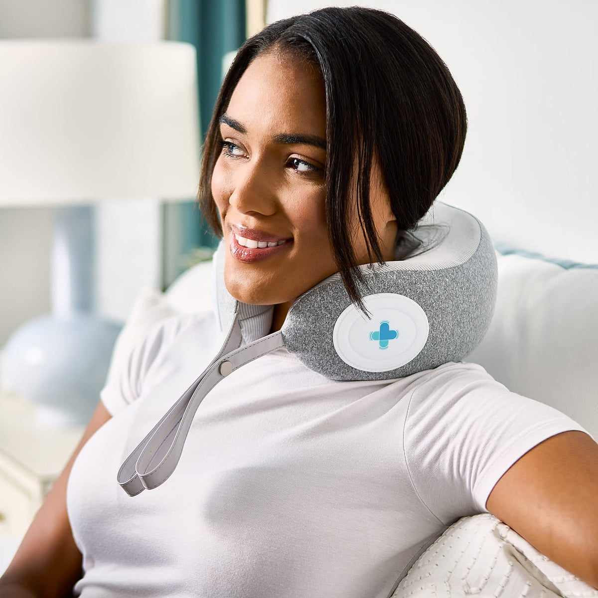 Woman relaxing on a couch with a MedMassager Neck Massager.