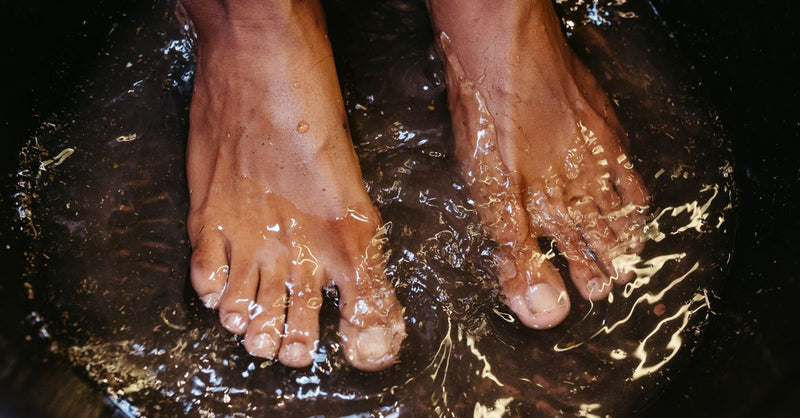 Close-up of male feet soaking in water for a relaxing spa treatment.