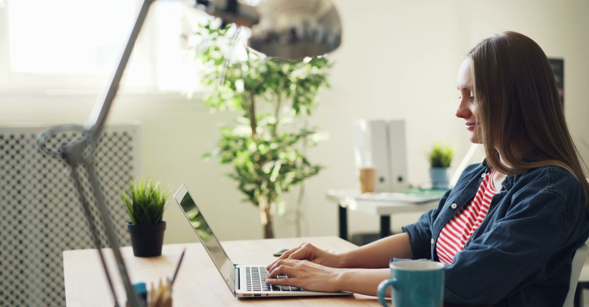 Woman working on a laptop at an office desk.