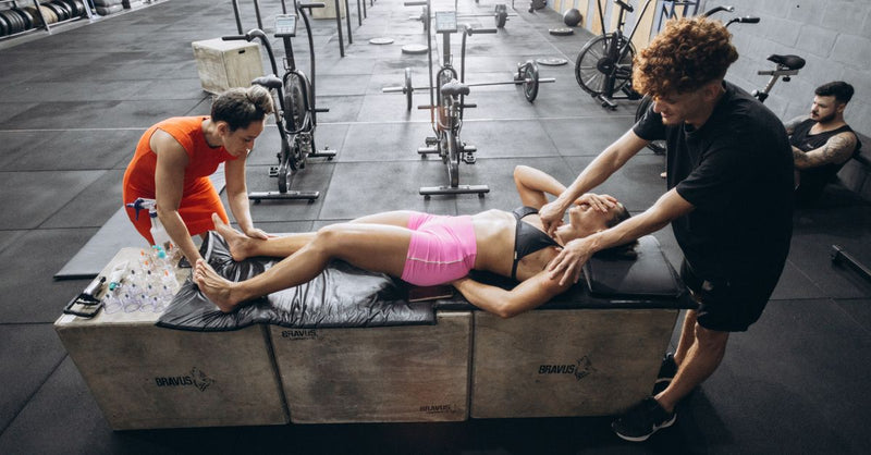 Athletes engage in recovery therapy with cupping and massage in a gym.