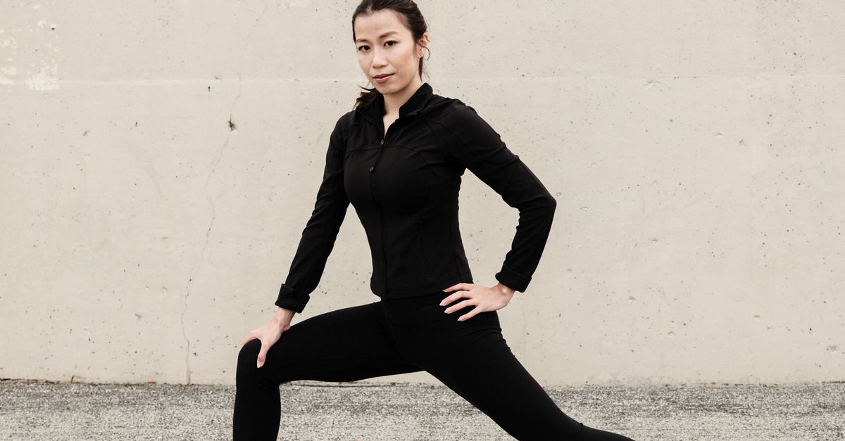 Woman doing a side lunge stretch for the inner thigh outdoors.