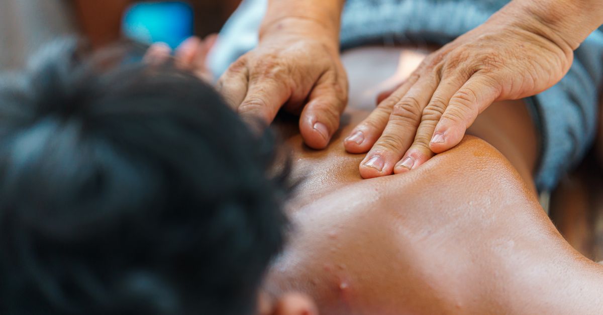 Close-up of hands performing a therapeutic back massage, promoting relaxation and wellness.