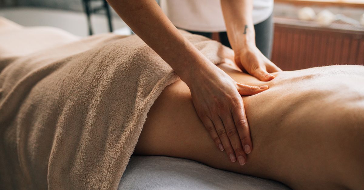 A serene massage session indoors highlighting hands-on body care and relaxation.