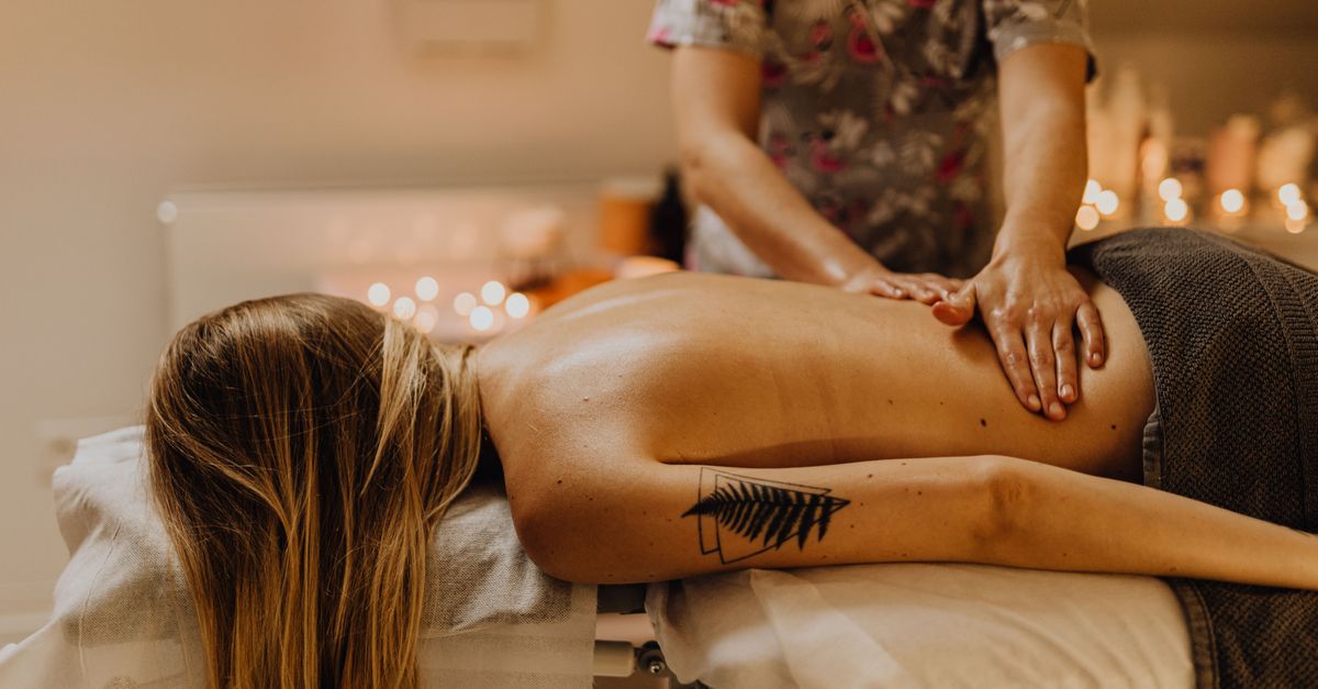 Woman receiving a therapeutic massage in a calm spa environment, promoting relaxation and wellness.