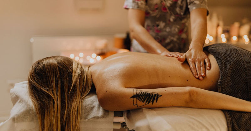 Woman receiving a therapeutic massage in a calm spa environment, promoting relaxation and wellness.