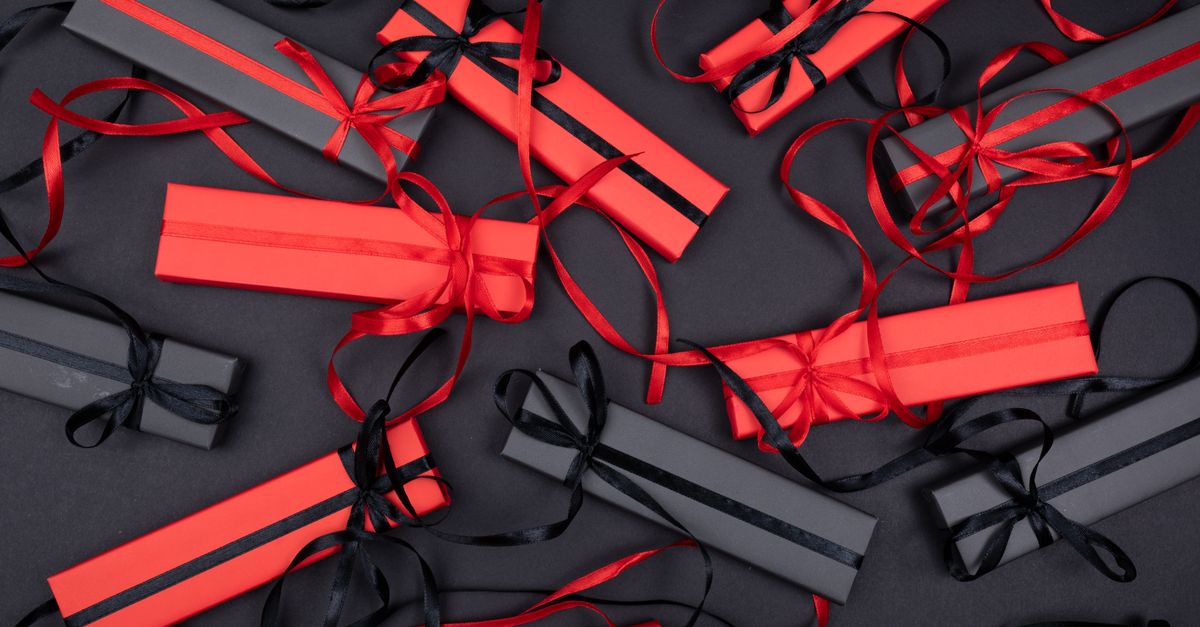 Stylish arrangement of red and black gift boxes tied with ribbons against a dark background.