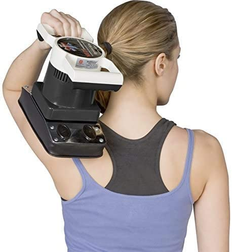 A woman in a blue tank top uses the MedMassager MMB04 Body Massager on her upper back and shoulder, with her back to the camera, seeking soothing pain relief.